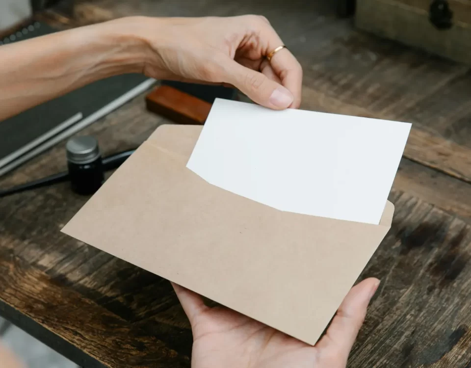 Ahşap masada zarfın içine yerleştirilen boş dilekçe kâğıdı, vergi dairesi ödeme emri tebliği ve itiraz dilekçesini simgeleyen görsel.