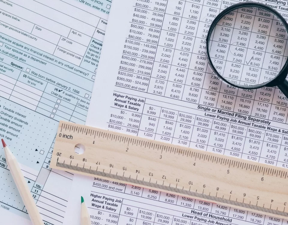 İkmalen tarh işlemini anlatan görsel; vergi formları üzerinde büyüteçle inceleme ve hesaplama tablosu.