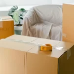 Kira Ödemeyen Kiracının Tahliyesi: Kiracının Temerrüt Sebebiyle Tahliyesi 2 Kiracının temerrüdü nedeniyle tahliye konulu makale görseli; taşınma kolileri ve bant ile kira bedelinin ödenmemesi nedeniyle tahliye sürecini simgeleyen görsel.