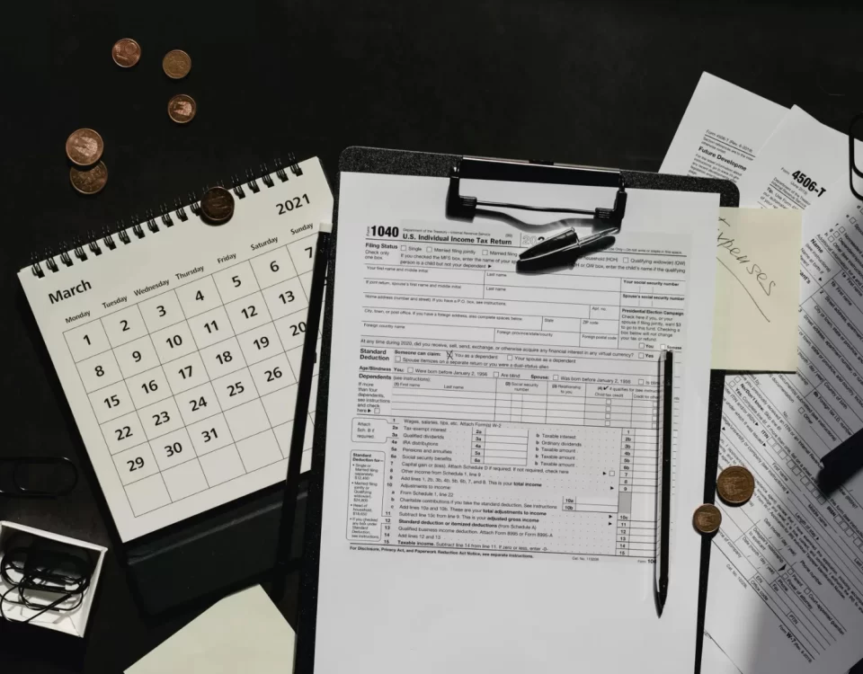 Vergi incelemesi konulu makale görseli; vergi formları, takvim ve büyüteç ile denetim sürecini simgeleyen masa düzeni.