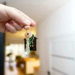Kiracının Evi Gösterme Yükümlülüğü 1 İstanbul kira avukatı gözetiminde, kiracının evi gösterme yükümlülüğünü ve taşınmazın yeni alıcılara veya kiracılara devri sürecini simgeleyen ev şeklinde anahtarlık tutan el görseli.