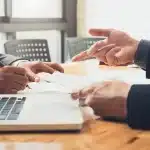 Şirket Hisse Devri 2026: Limited ve Anonim Şirketlerde Geçerlilik, Tescil ve Yargısal Uygulama 1 Şirket hisse devri sözleşmesi imzalayan iş ortakları ve masadaki resmi evraklar.