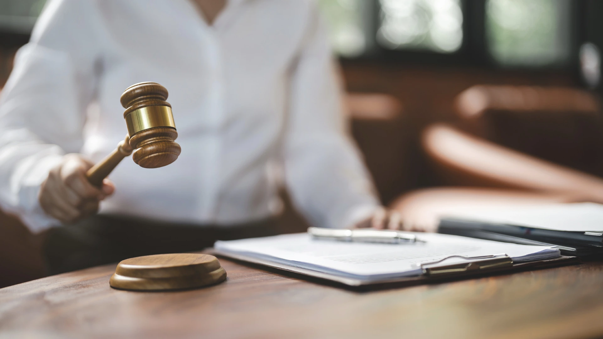 Kamu ihalelerinde usulsüzlük veya sözleşme ihlali iddiasıyla verilen ihaleden yasaklama kararlarını, hak mahrumiyeti doğuran idari yaptırımların idare mahkemesi kanalıyla durdurulmasını sembolize eden adalet tokmağı, dava dosyası ve kalem içeren kurumsal idare hukuku görseli.