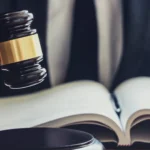 İlamlı İcra Takibine İtiraz: İcra Emrine Karşı Hukuki Yollar 2 Bir mahkeme kararına dayanan ilamlı icra takibine itiraz prosedürünü, icra emrine karşı icra mahkemesinde açılan icranın geri bırakılması davasını, hukuk kitabını inceleyen hakimi ve mahkeme tokmağını sembolize eden kurumsal adalet görseli.