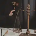 İtirazın İptali ve Kaldırılması Davaları Arasındaki Farklar 1 İcra takibine itiraz edilmesiyle duran takibin devamını sağlamak amacıyla açılan itirazın iptali ve kaldırılması davalarını, adalet terazisini ve mahkeme hakimi figürünü sembolize eden kurumsal adalet görseli.