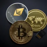Kripto Para Vergisi: Kazançların Vergilendirilmesi ve Beyan Rehberi 2 Kripto varlık yasası ve vergi mevzuatı uyarınca dijital varlıkların alım satım kazançlarına getirilmesi planlanan kripto para vergisi uygulamalarını sembolize eden; siyah zemin üzerinde duran fiziksel altın Bitcoin (BTC), gümüş Ethereum (ETH) ve altın Ripple (XRP) madeni paraları ile sağ alt köşede yer alan bir mikro SD hafıza kartının üstten görünümü.