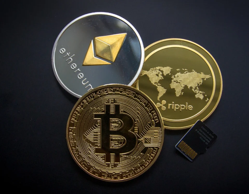 Kripto Para Vergisi: Kazançların Vergilendirilmesi ve Beyan Rehberi 8 Kripto varlık yasası ve vergi mevzuatı uyarınca dijital varlıkların alım satım kazançlarına getirilmesi planlanan kripto para vergisi uygulamalarını sembolize eden; siyah zemin üzerinde duran fiziksel altın Bitcoin (BTC), gümüş Ethereum (ETH) ve altın Ripple (XRP) madeni paraları ile sağ alt köşede yer alan bir mikro SD hafıza kartının üstten görünümü.