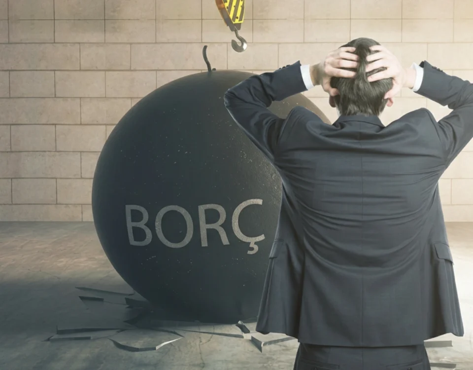 Mirasçının Borçlardan Sorumluluğu: Mirasbırakanın Borçları Kime Geçer? 8 Türk Medeni Kanunu uyarınca mirasbırakanın vefatı ile tereke borçlarının yasal varislere geçmesini ve mirasçının borçlardan sorumluluğu kapsamında doğan müteselsil şahsi yükümlülükleri sembolize eden; açık gri masa üzerinde boş beyaz bir yasal evrak, siyah bir imza kalemi, beyaz maket ev figürü, okuma gözlüğü ve ahşap hakim tokmağını gösteren kurumsal miras ve icra hukuku görseli.