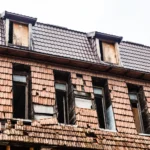 Riskli Yapı Tespitine İtiraz: 6306 Sayılı Kanun Kapsamında Rehber 2 6306 sayılı Kentsel Dönüşüm Kanunu kapsamında karot örneği alınarak depreme dayanıksız olduğu iddia edilen eski binanın görünümü ve bu idari rapora karşı yapılacak riskli yapı tespitine itiraz prosedürleri ile kentsel dönüşüm iptal davası süreçlerini sembolize eden; dış cephe kiremitleri yıpranmış, pencereleri ve çatısı deforme olmuş çok katlı eski ahşap ve kagir yapı modelinin alt açıdan dış görünümü.