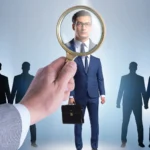 Bir büyüteç ile takım elbiseli bir çalışanın yakından incelenmesi; İstanbul'daki işverenlerin personellerini seçerken ve denetlerken hukuken tabi oldukları adam çalıştıranın sorumluluğu ilkesini temsil eder.